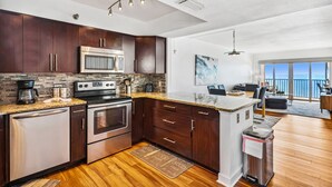 Una cocina moderna con armarios de madera oscura, electrodomésticos de acero inoxidable y encimera de granito.