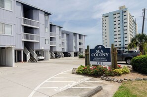 Un edificio de varios pisos con un cartel que dice 'Sea Colony Oceanfront Condominiums'.