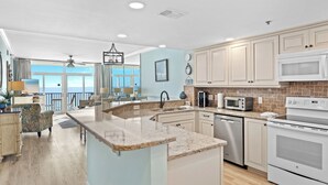 Una cocina moderna con una isla central, electrodomésticos integrados y vistas al exterior.