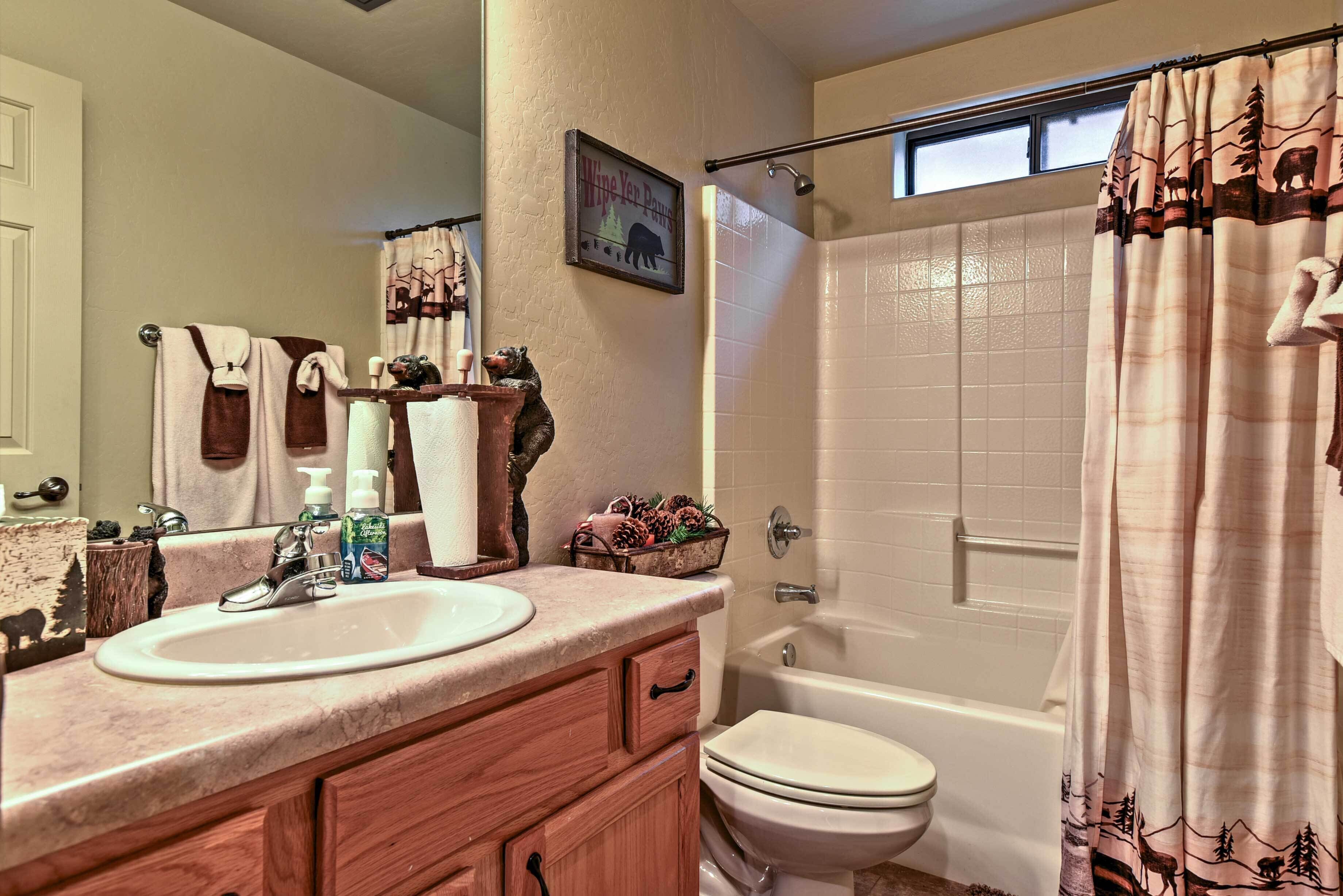 A bathroom with a sink, mirror, and a bathtub.