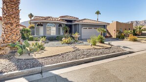 A residential house with a tiled roof, a garage, and a landscaped garden with cacti and small plants. - Heated Pool at 3 BR Home: 5 Mi to Coachella! (La Quinta)