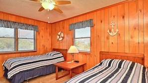 A room with two beds, a ceiling fan, a table, and windows with curtains. - OH1213- Just 300 Feet to Beach, 4 BRs, Ocean/Lighthouse Views, Dog Friendly! (Corolla)