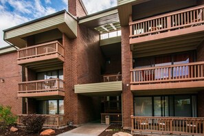 A multi-story building with balconies, brick exterior, and large windows.
