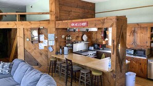 Een rustieke keuken met houten wanden, een bar en een zithoek.