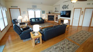 A spacious living room with a fireplace, a large TV, and comfortable seating. - KH4004- Oceanside-5 BRs, Elevator, Pool Table, Private Pool and Hot Tub! (Kitty Hawk)