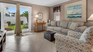 A living room with a sofa, a coffee table, a side table, and a painting on the wall. - Comfortable Townhome with a Short Walk to Community Pool and the Beach! (Miramar Beach)