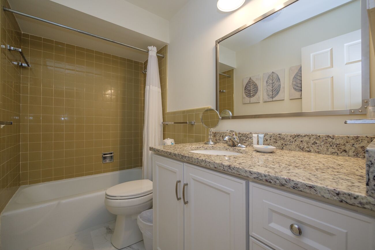 A bathroom with a bathtub, toilet, and a shower area.