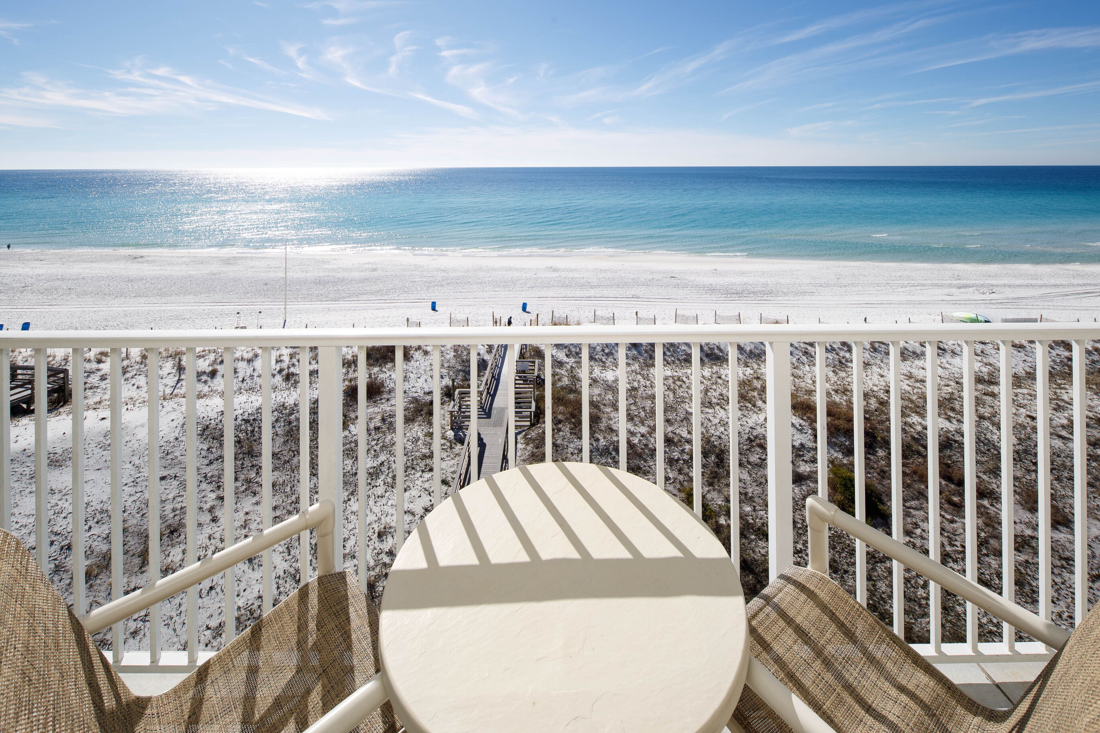 A balcony with a view of a beach and ocean.