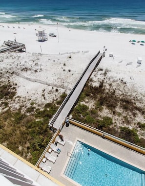 A pool with a view of the beach and ocean.