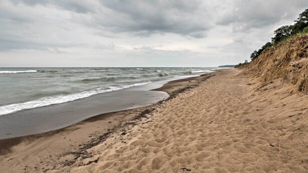 Ein Strand mit sandigem Ufer und Wellen.