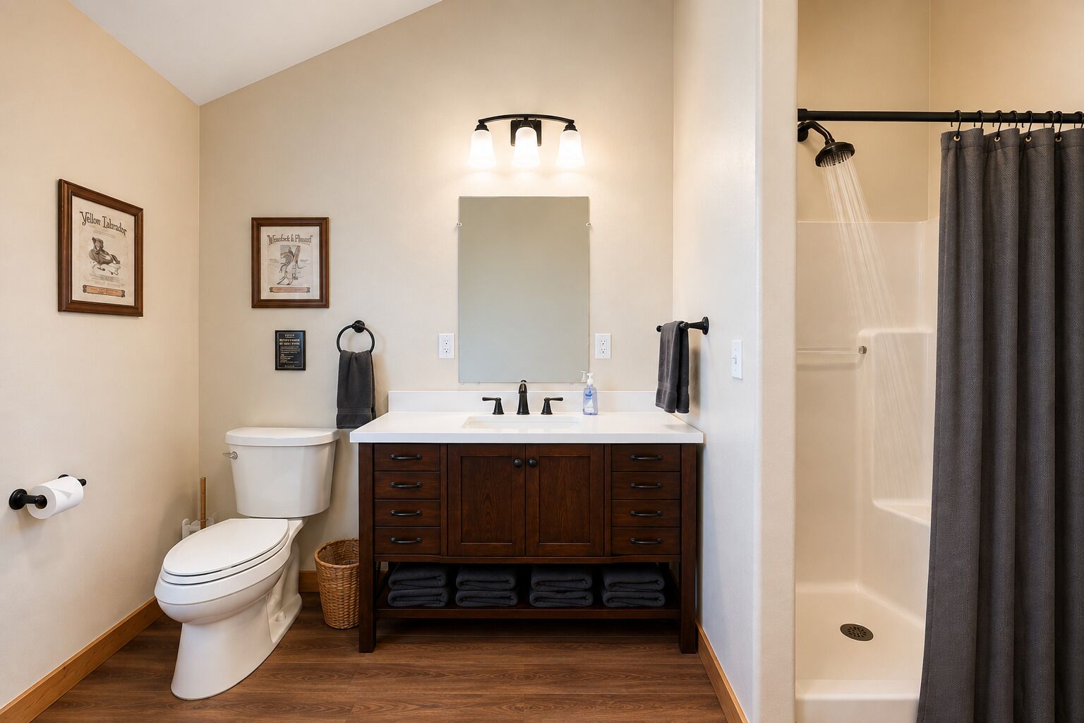 Een badkamer met toilet, wastafel, badkamermeubel en douche.