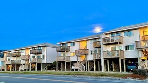 Una hilera de edificios de varios pisos con balcones y barandillas de madera, probablemente un hotel o complejo de apartamentos.