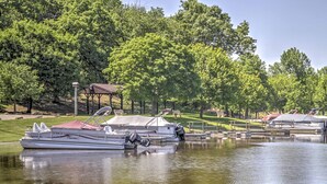 A boat docked at a marina with a gazebo and picnic tables in the background.