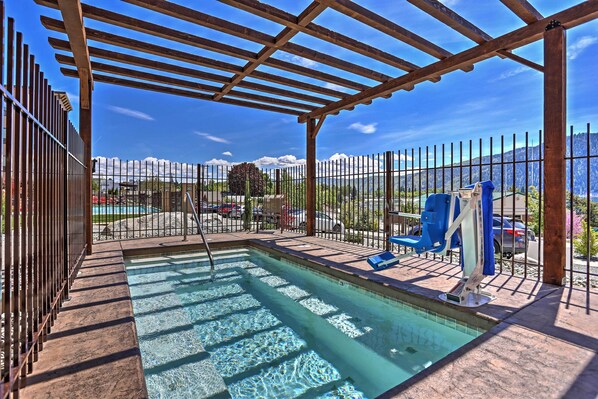 A pool area with a pergola, a fenced pool, and a view of mountains. - Marvelous Manson Condo, Steps to Lake Chelan Beach (Manson)
