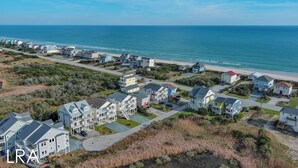 A coastal residential area with houses along the beach, a clear view of the ocean, and a well-maintained landscape. - Stay Coastal at Fenway at the Beach (North Topsail Beach)