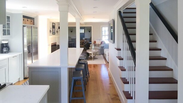 A modern kitchen with white cabinetry, a central island, and a dining area with a sofa and coffee table. - School Street in the Old Village!! Charming, new construction with attention to detail! (Chatham)