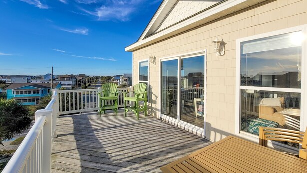 A wooden deck with a view of a residential area. - Anchored Inn: Family-Friendly 4BR with Pool (Surf City)