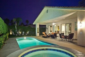 A swimming pool with lounge chairs and a dining area with tables and chairs. - Beautiful Palm Springs Home - 3 Bed 3 Bath Home (Palm Springs)