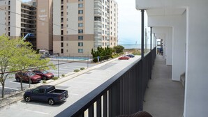 A hotel with a parking lot, a pool, and a view of the ocean. - Just Steps to the Beach, this 3BDR Condo has Coastal Decor and Free WiFi and is Located on the North End of Town! (Ocean City)