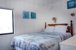 Un dormitorio con cama, ventana y decoración en la pared.