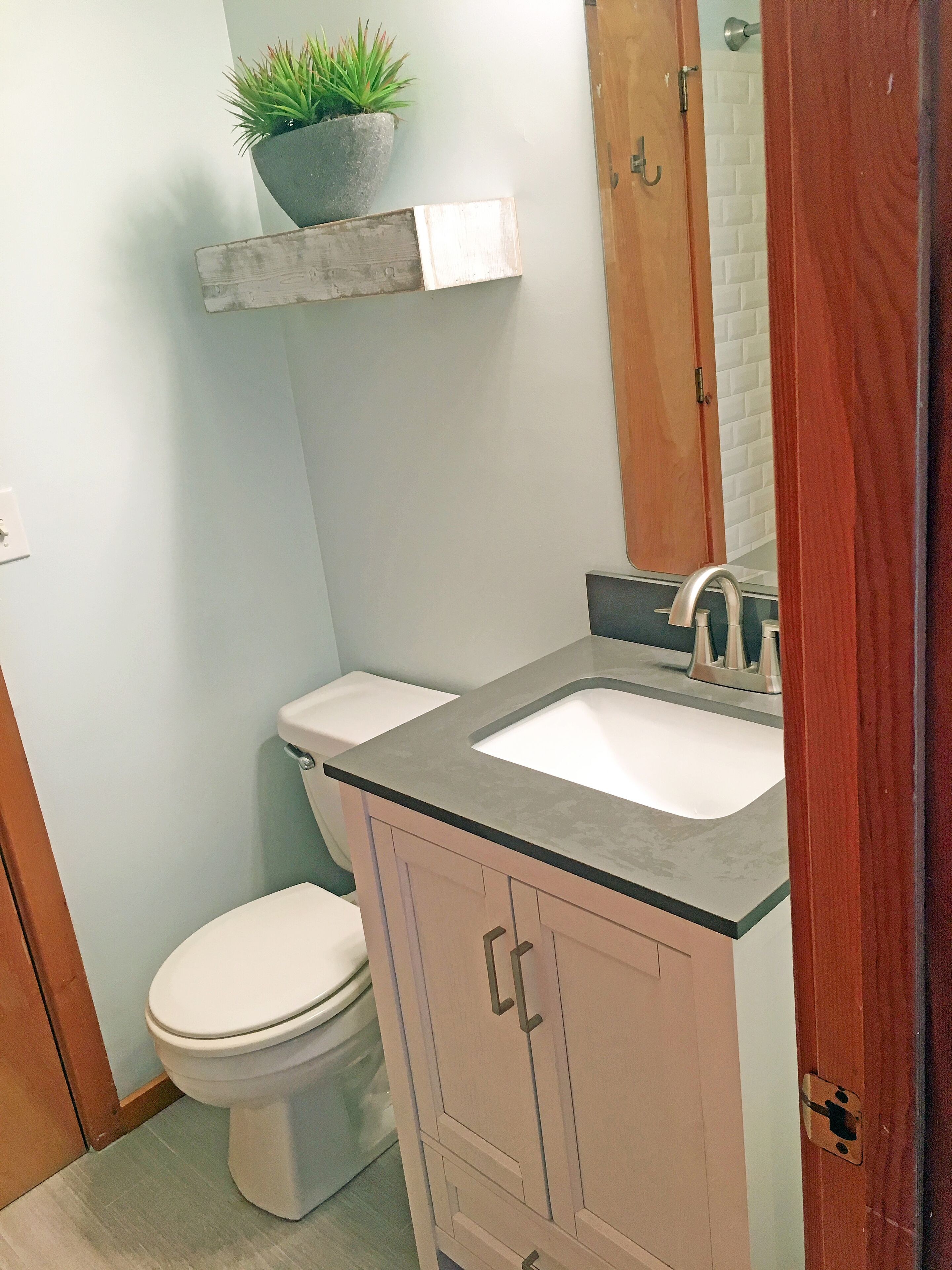 Une petite salle de bain avec des toilettes, un lavabo et un meuble de rangement.