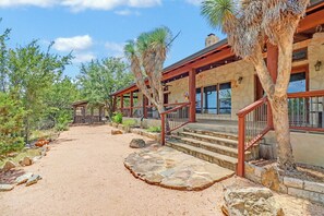 A building with a stone facade, wooden deck, and a staircase leading to a covered area. - Southern Cross I Stargazing, hot tub, sleeps up to 8! (Wimberley)