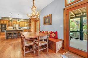 A spacious kitchen with wooden cabinets, a central island, and a chandelier. - Southern Cross I Stargazing, hot tub, sleeps up to 8! (Wimberley)