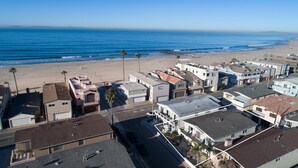 Zona residencial costera con casas, una playa y una vista despejada del océano.