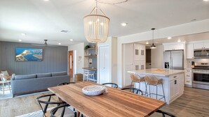 Una cocina moderna con armarios blancos, una isla central y electrodomésticos de acero inoxidable.
