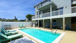 A swimming pool with lounge chairs and a deck area.