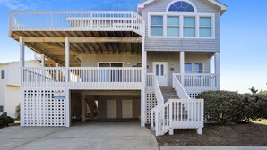 A two-story building with a balcony on the upper level, a covered entrance, and a staircase leading to the upper floor.