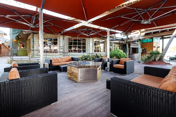 An outdoor seating area with wicker furniture and a central glass-top coffee table.