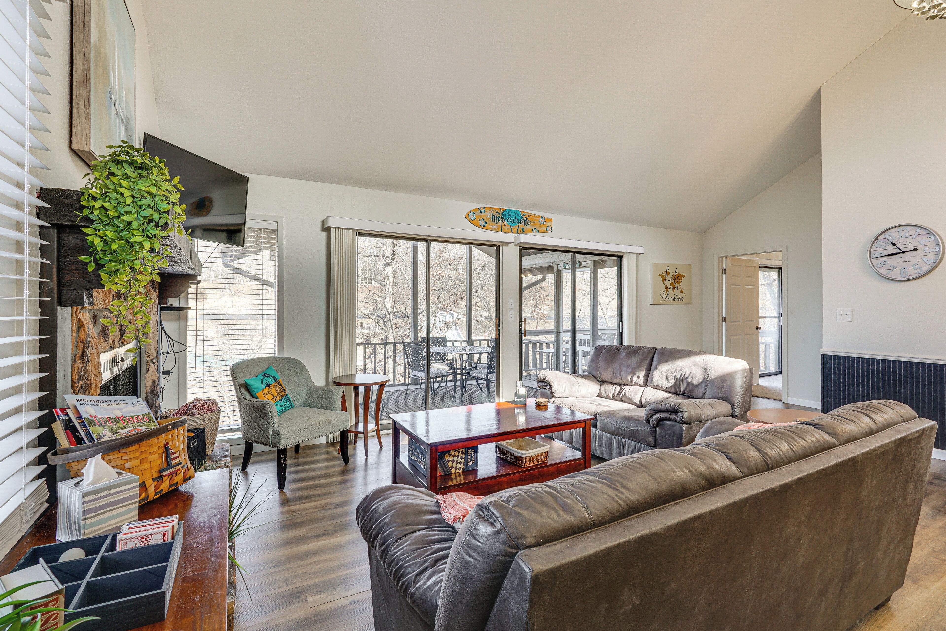 A spacious living room with a large window, a sofa, a coffee table, and a chair.