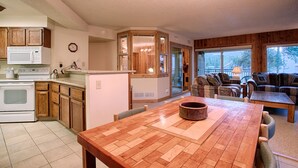 Eine geräumige Küche mit Holzausstattung, einer Mikrowelle und einem Herd. Es gibt einen Essbereich mit Holztisch und Stühlen sowie eine gemütliche Sitzecke mit einer Couch und Sesseln.