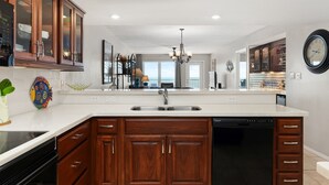 A modern kitchen with wooden cabinets, a central island, and a dishwasher.