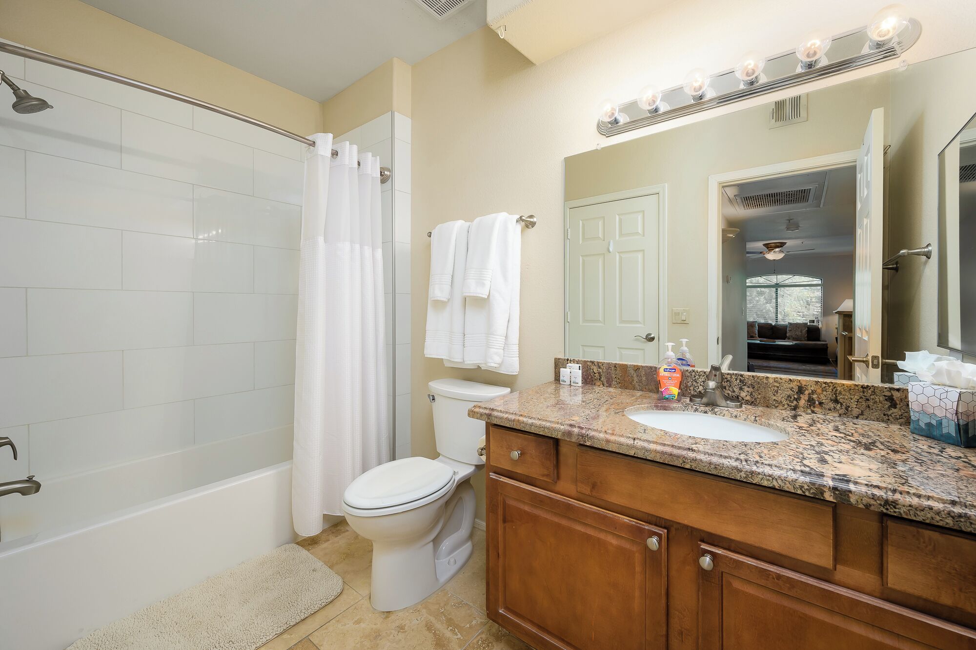 A bathroom with a shower, toilet, sink, and vanity.