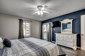 Relax in this serene bedroom with a large bed, ceiling fan, and flat-screen TV.