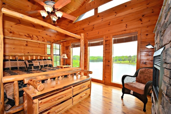 2nd floor King Size Bedroom with electric fireplace and TV with lakeside views and access to balcony.