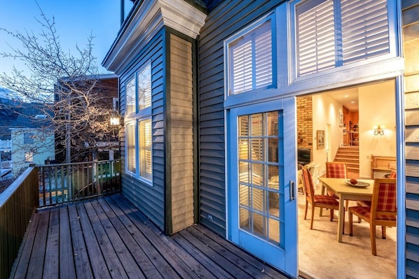 A wooden deck with a dining area featuring a table and chairs.