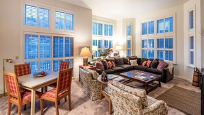 A spacious living room with a dining area, large windows with shutters, and a cozy fireplace. - Labor Day Sale - Limited Time Offer, Save up to 30% (Park City)