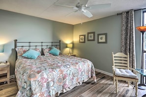 A bedroom with a bed, a chair, a ceiling fan, and a window with curtains. - Chic Myrtle Beach Seaside Escape w/ Pool Access! (Myrtle Beach)