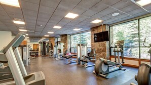A gym with cardio machines, weight stations, and a stone wall. - Walking distance to Main Street. Pool and Hot Tubs with a Beautiful View! (Breckenridge)