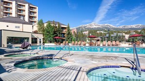A pool area with hot tubs, lounge chairs, and a mountain view. - Walking distance to Main Street. Pool and Hot Tubs with a Beautiful View! (Breckenridge)
