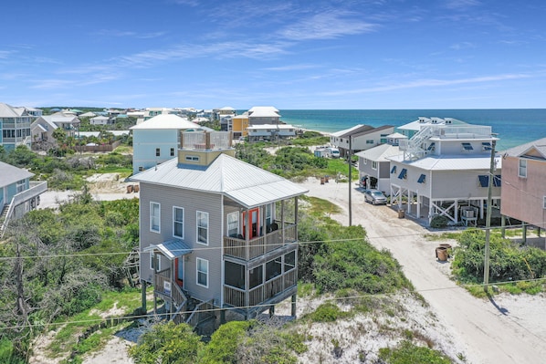 A coastal residential area with houses featuring balconies and a beach view.