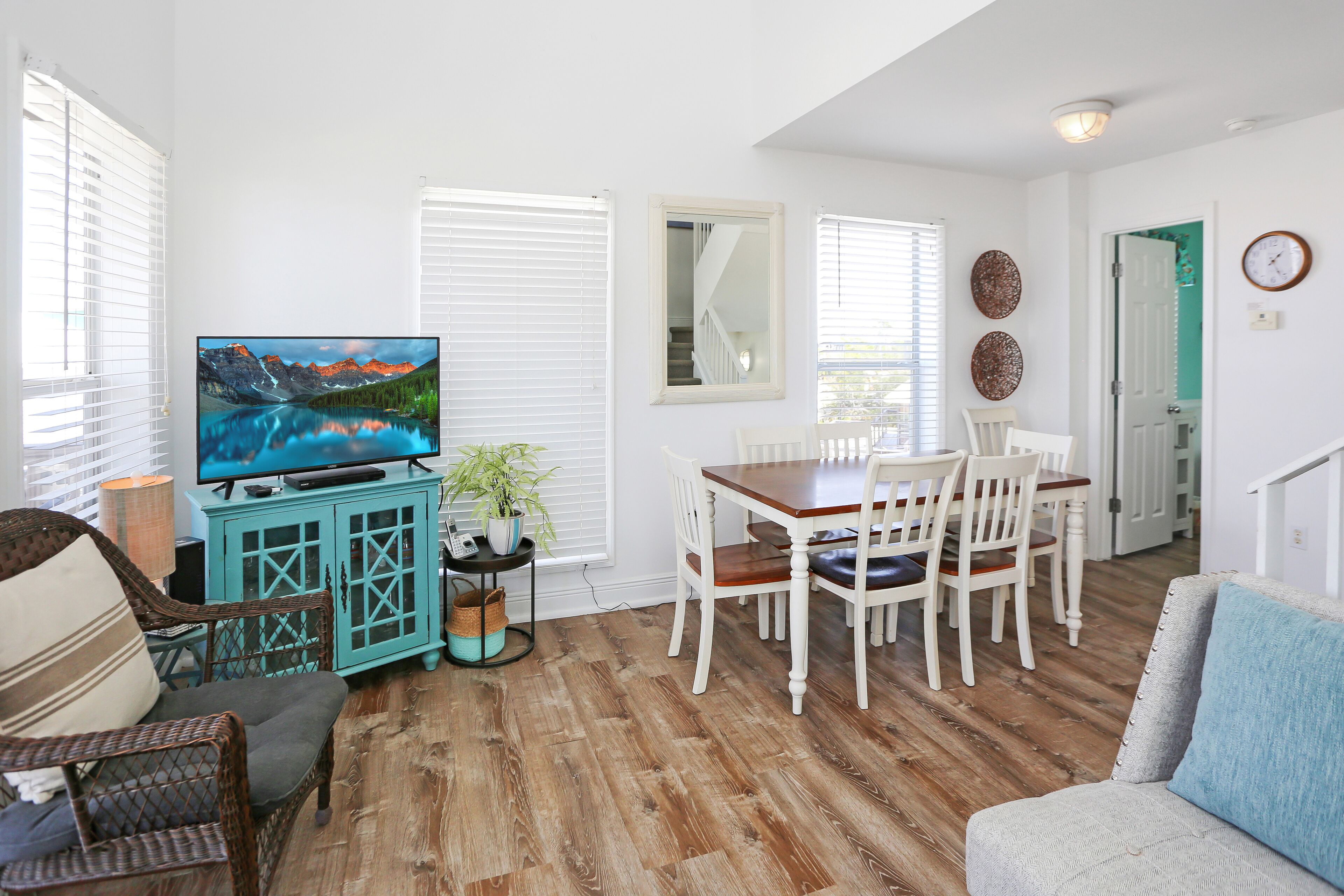A living room with a television, dining table, chairs, and a sofa.