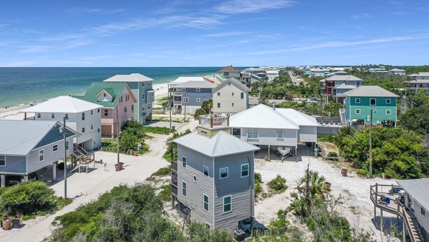 A coastal residential area with houses near the beach, featuring a mix of single and multi-story buildings, some with attached garages. - Pet Friendly - Steps From Beach - Narrow Escape (Cape San Blas)
