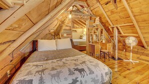 Accogliente camera da letto in soffitta con un letto, una scrivania e una sedia.