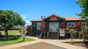 A building with a sign reading "Kauai Coffee Company" and a "Gift Shop" sign above the entrance.