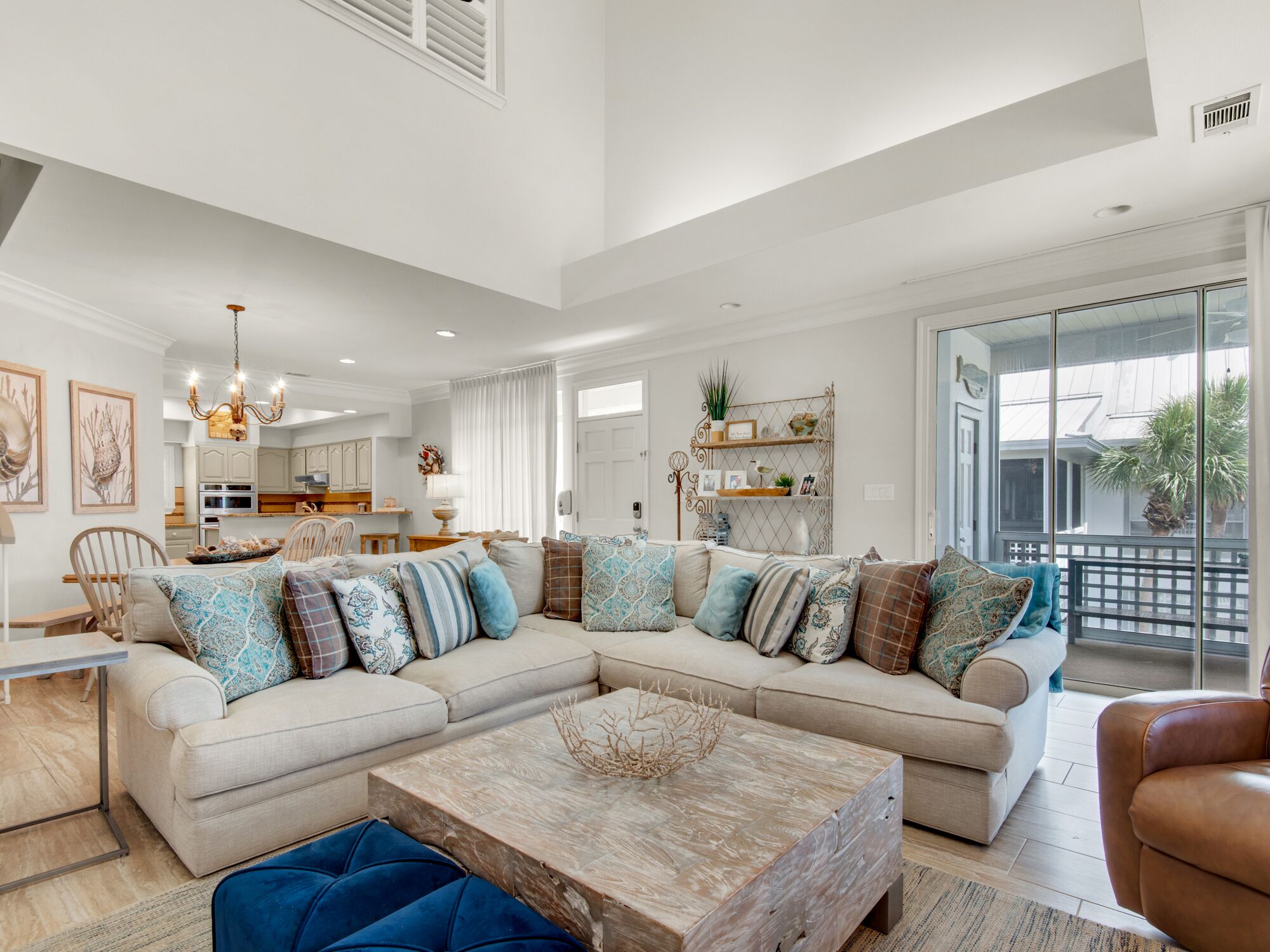 A spacious living room with a large sectional sofa, a wooden coffee table, and a view of the outside.
