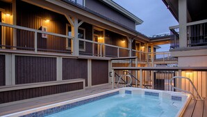 A swimming pool with a wooden deck and a building with multiple balconies. - Ski-in/ski-out, Hot tubs and sauna, Fireplace, Sleeps 8! (Breckenridge)